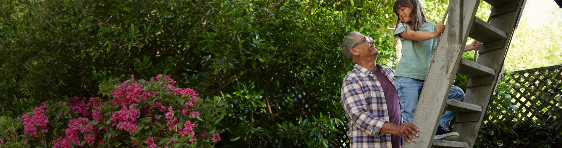 A WATCHMAN patient helping his granddaughter climb a treehouse ladder.