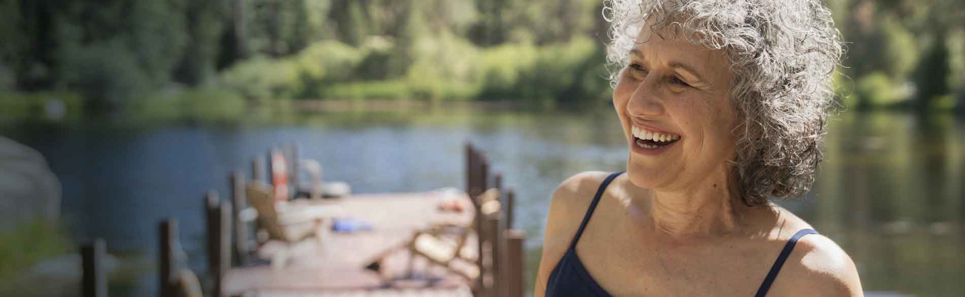 Woman swimmer smiling on a dock.