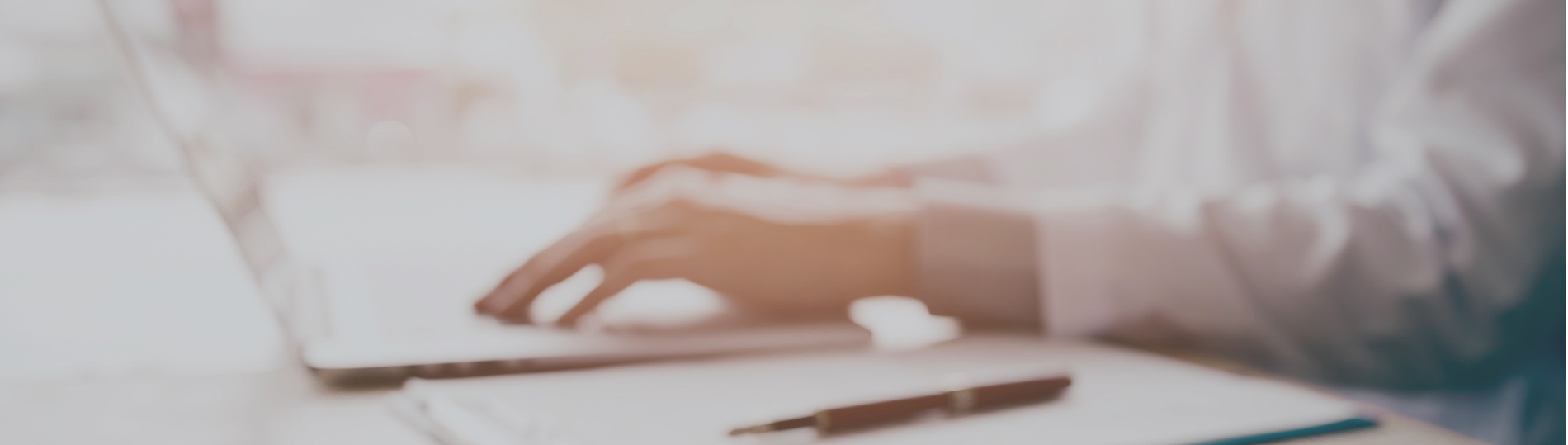 hands of a person typing on a laptop at a desk