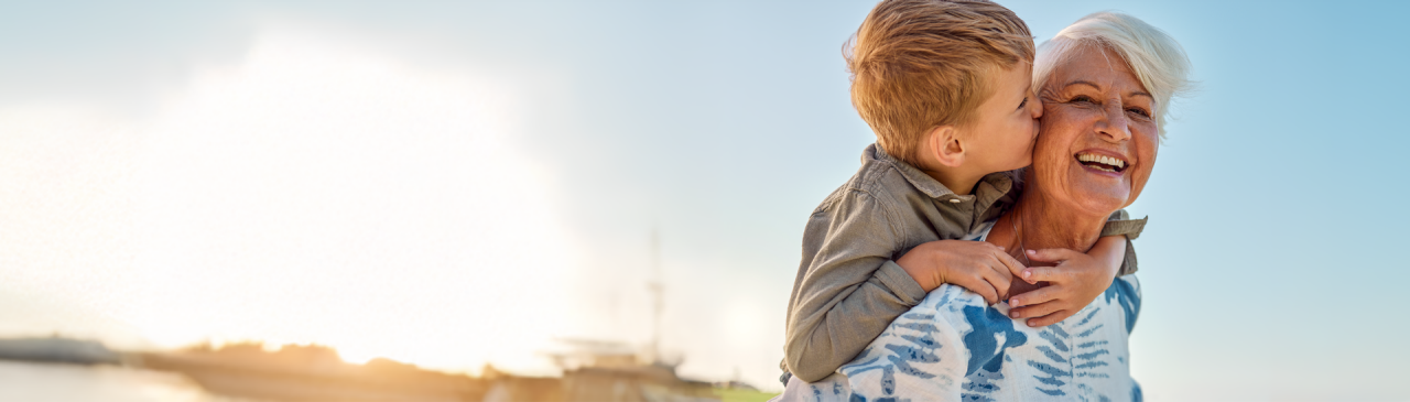 Eine Frau und ihre Enkelin toben im Freien herum.