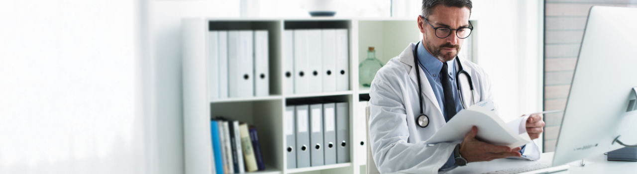 Physician in office reading documents