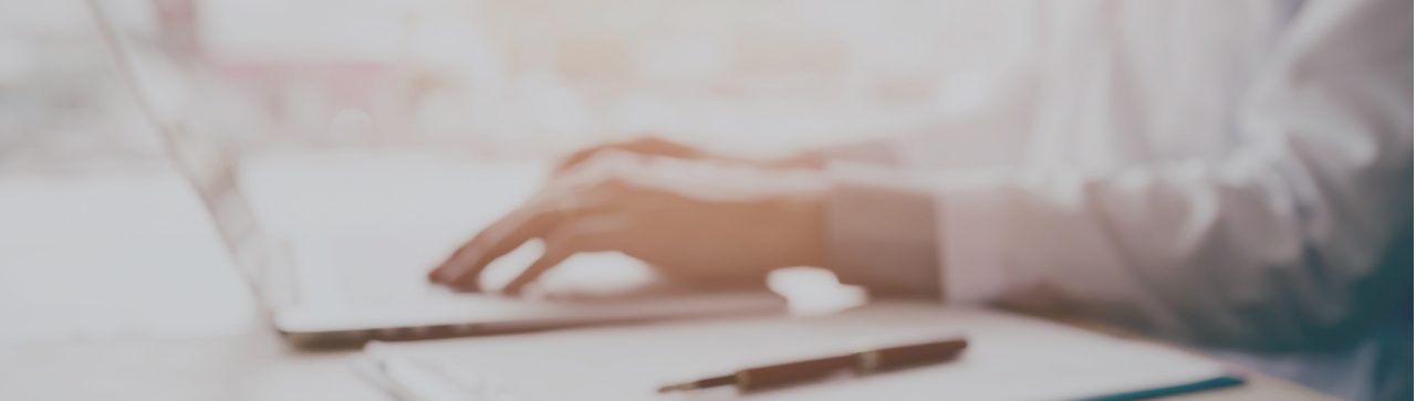 A faded image of hand typing on a keyboard.