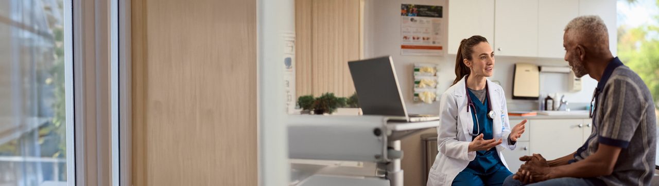 A patient and doctor in an exam room having a conversation.