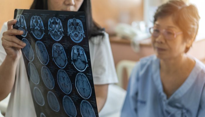 A healthcare professional showing medical images to a patient in an exam room.